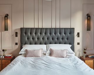 Traditional bedroom with gray headboard and panel wall