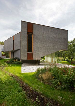 Grey abstract building with surrounding garden