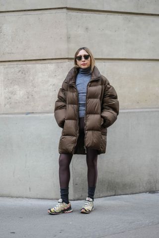 woman wearing puffer jacket, turtleneck, leggings, and sneakers