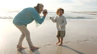 Best budget video camera - grandmother records footage of her grandson playing on the beach