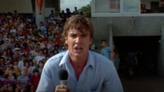 Dennis Quaid holds a microphone while trying to warn people at a water show in Jaws 3-D.