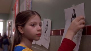 Michelle Trachtenberg taping photo on wall in Harriet the Spy.