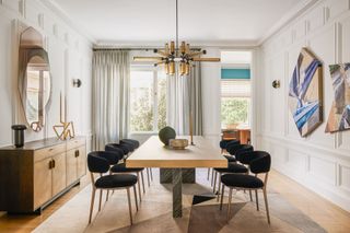 A light and spacious dining room with statement artwork and paneled wall details