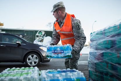 Michigan National Guard member loads water at a Flint distribution center