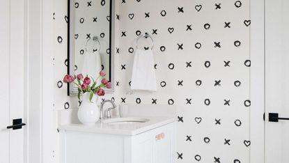 Mono bathroom with white vanity and hearts and kisses wallpaper
