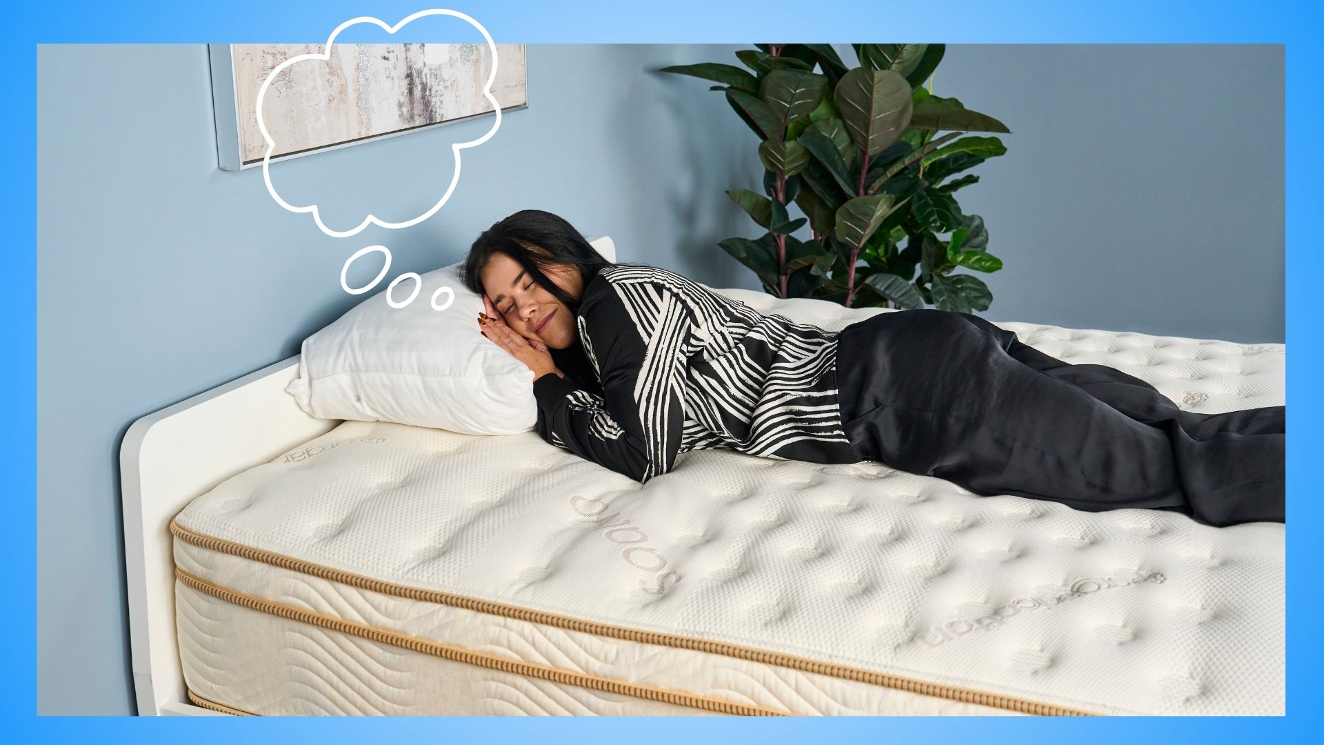 A woman with black hair wearing black and white pyjamas sleeping on Saatva Solaire mattress in sleep studio with a thought bubble