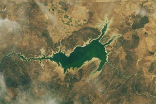 This NASA satellite image shows the manmade Valdecañas Reservoir as it appeared on July 25, 2019. Low water levels allowed the ancient Dolmen of Guadalperal to reappear on the North side of the lake for the first time in more than 50 years.