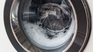 A running washing machine with suds in the load