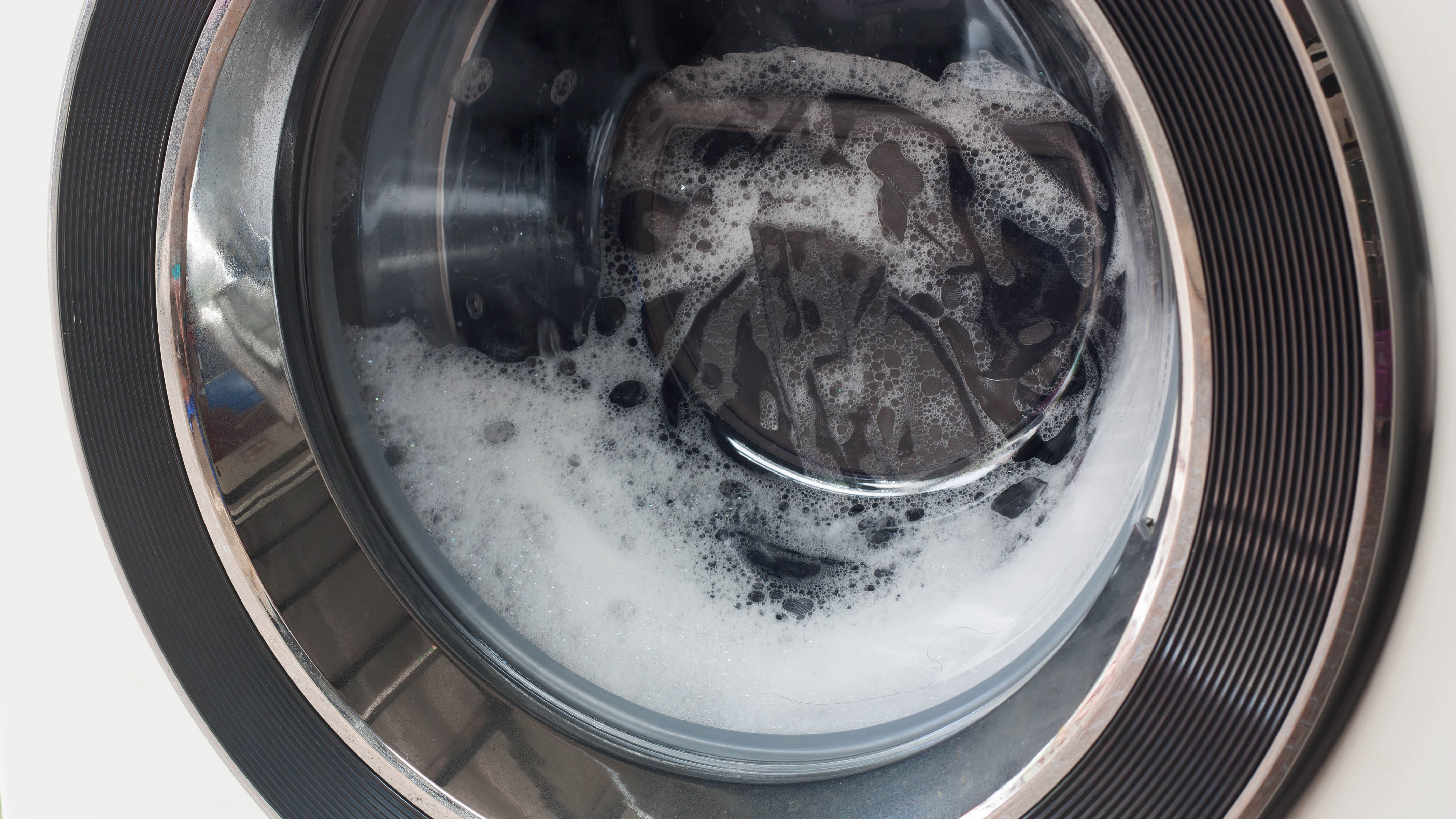 Eine laufende Waschmaschine mit Schaum in der Ladung