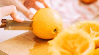 Oranges and slices of orange on chopping board