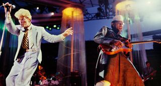 David Bowie strikes a pose on the mic onstage with Carlos Alomar in '83.