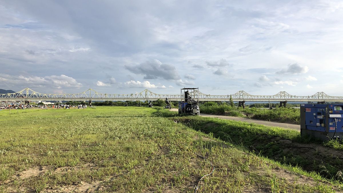 In a huge field of green, Martin Audio line array speakers are used to amplify a coming fireworks show. 