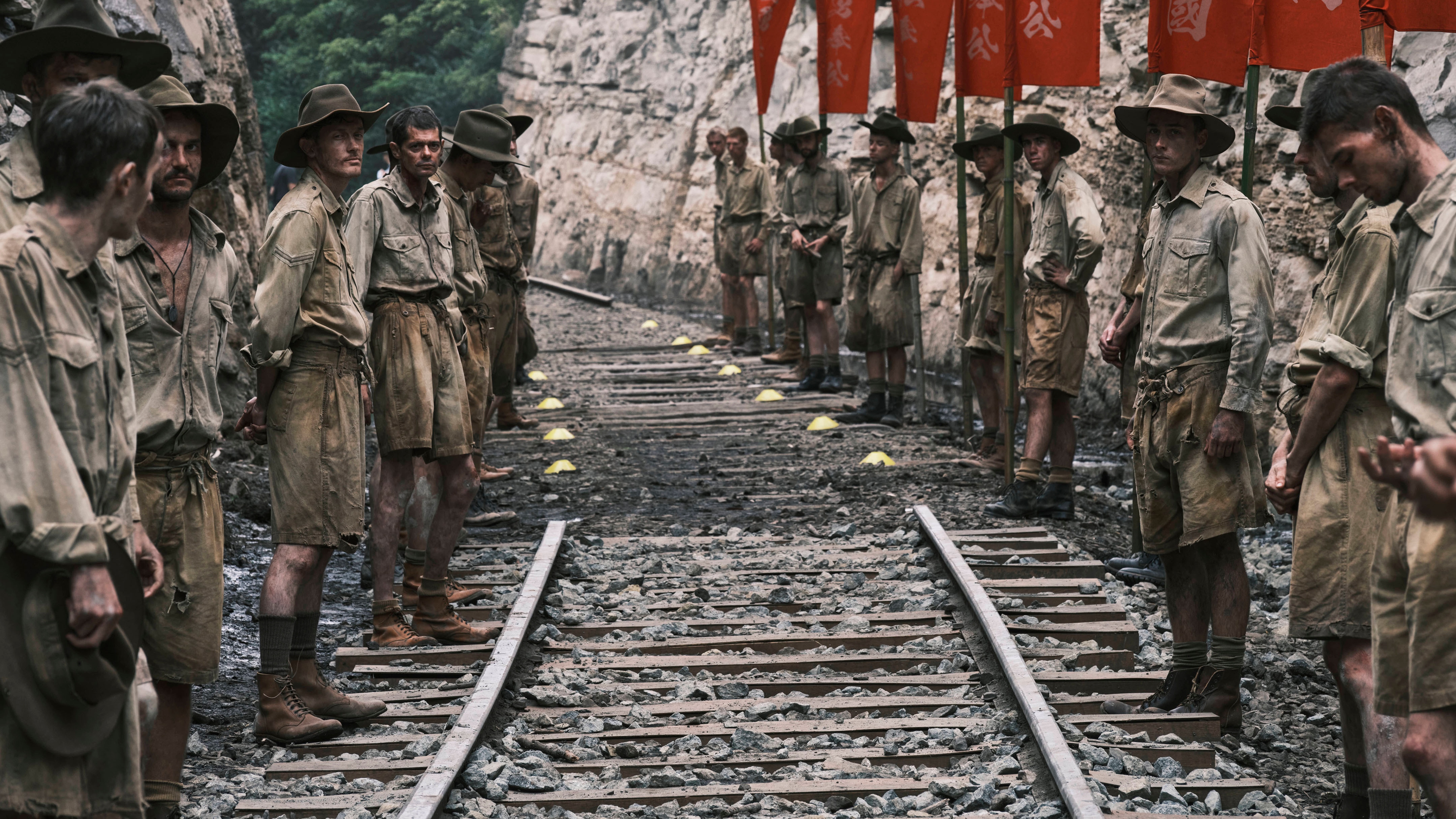 The Narrow Road To The Deep North cast standing along a train track