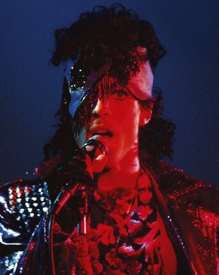 Singer Prince on stage bathed in a red light