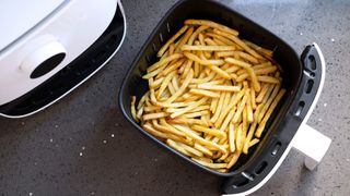 chips in a white air fryer on a kitchen countertop