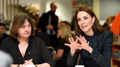 Catherine, Duchess of Cambridge (R) reacts as she meets with employees and their families from the local Michelin factory, at a community centre in Dundee, eastern Scotland, on January 29, 2019