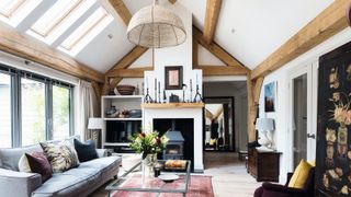 oak frame living room with large pendant light and roof lights