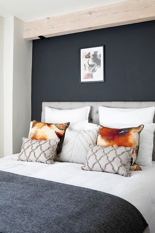 Dark grey bedroom with orange cushions