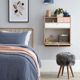 bedroom with teal wall colour and wooden shelves with stool