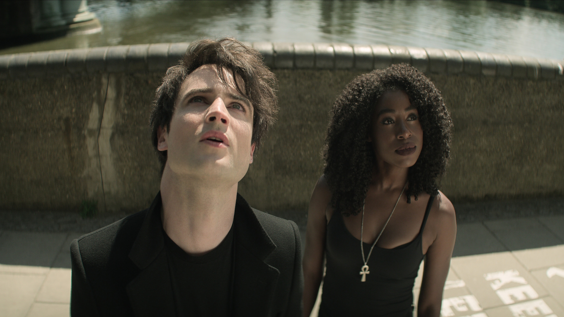 Tom Sturridge's Dream and Kirby Howell-Baptiste's Death look at a building off screen in Netflix's The Sandman TV show