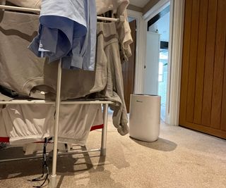 dehumidifier next to drying rack with laundry