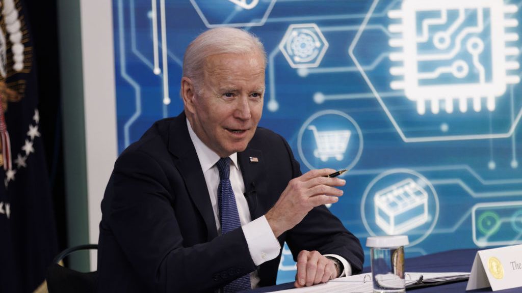 Joe Biden at a desk at a tech conference. 