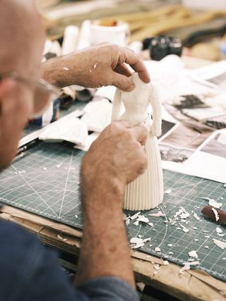 Man carving Dior dress in miniature