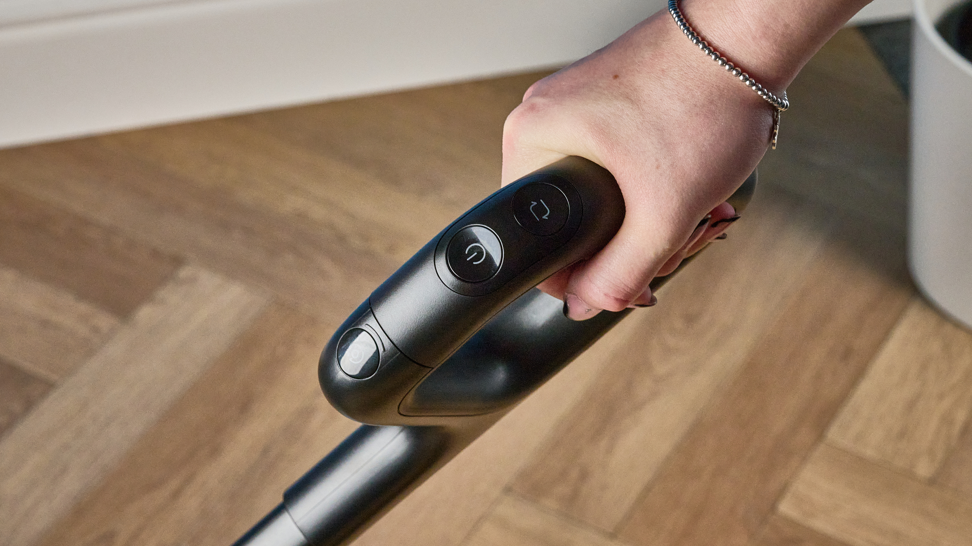 Handle of the Roborock F25 ACE Pro photographed on a brown wood floor