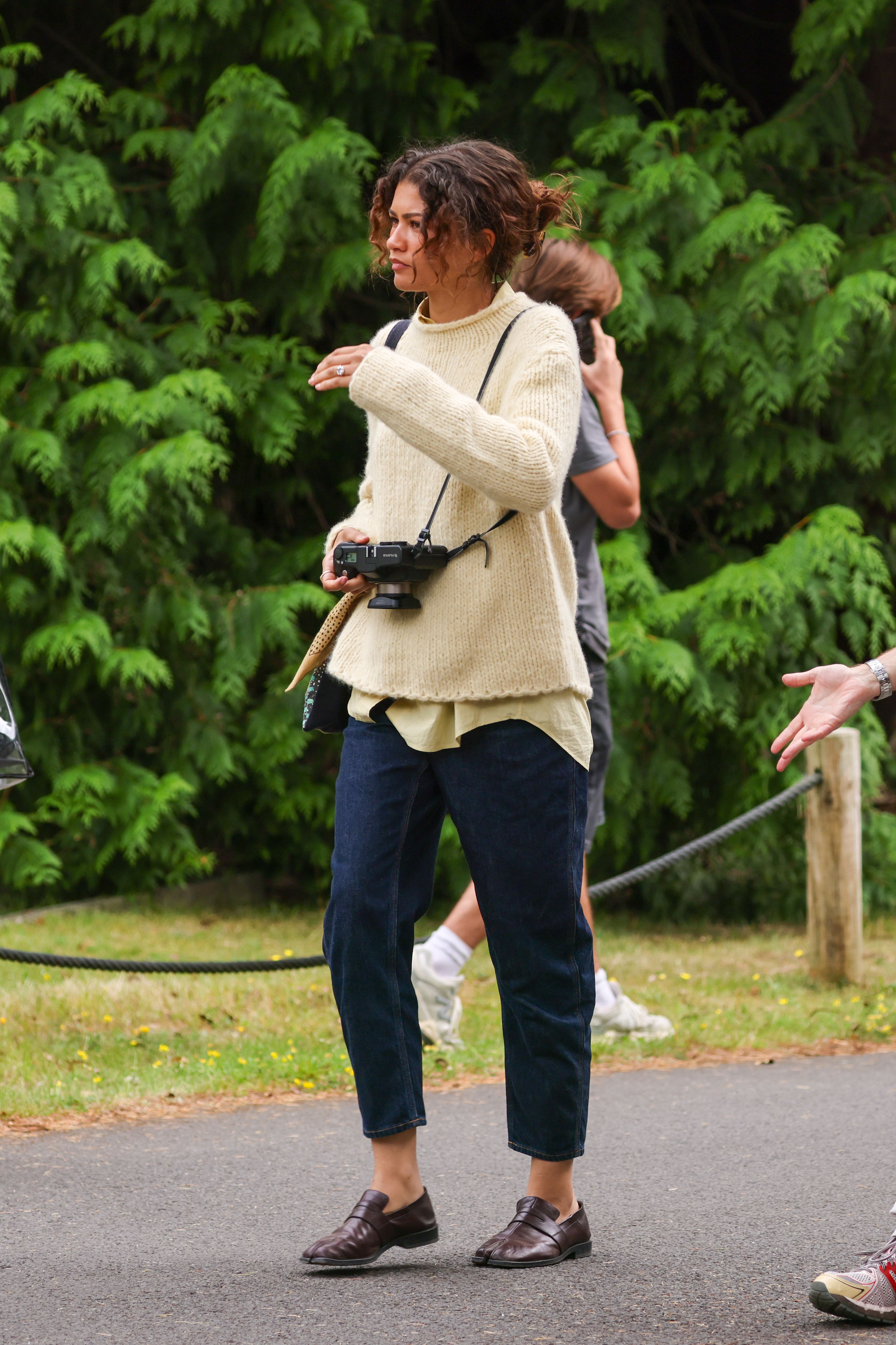 Zendaya fall-ified summer 2025's butter yellow trend in a mohair sweater and dark-wash jeans.