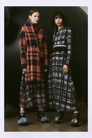 Models wear dark checkered oversized dresses in black and red