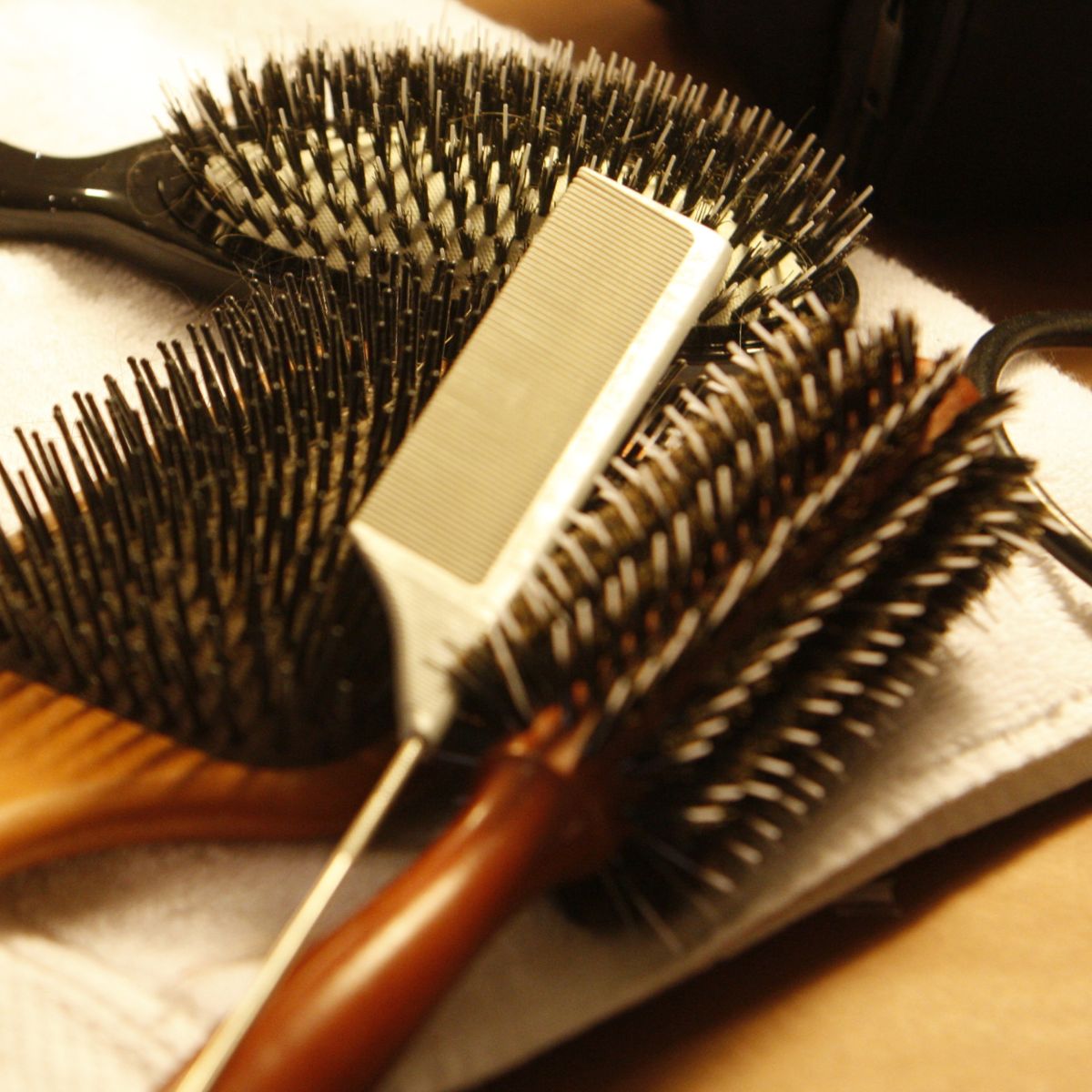 A closeup of hair brushes backstage during fashion week - how to clean your hairbrush