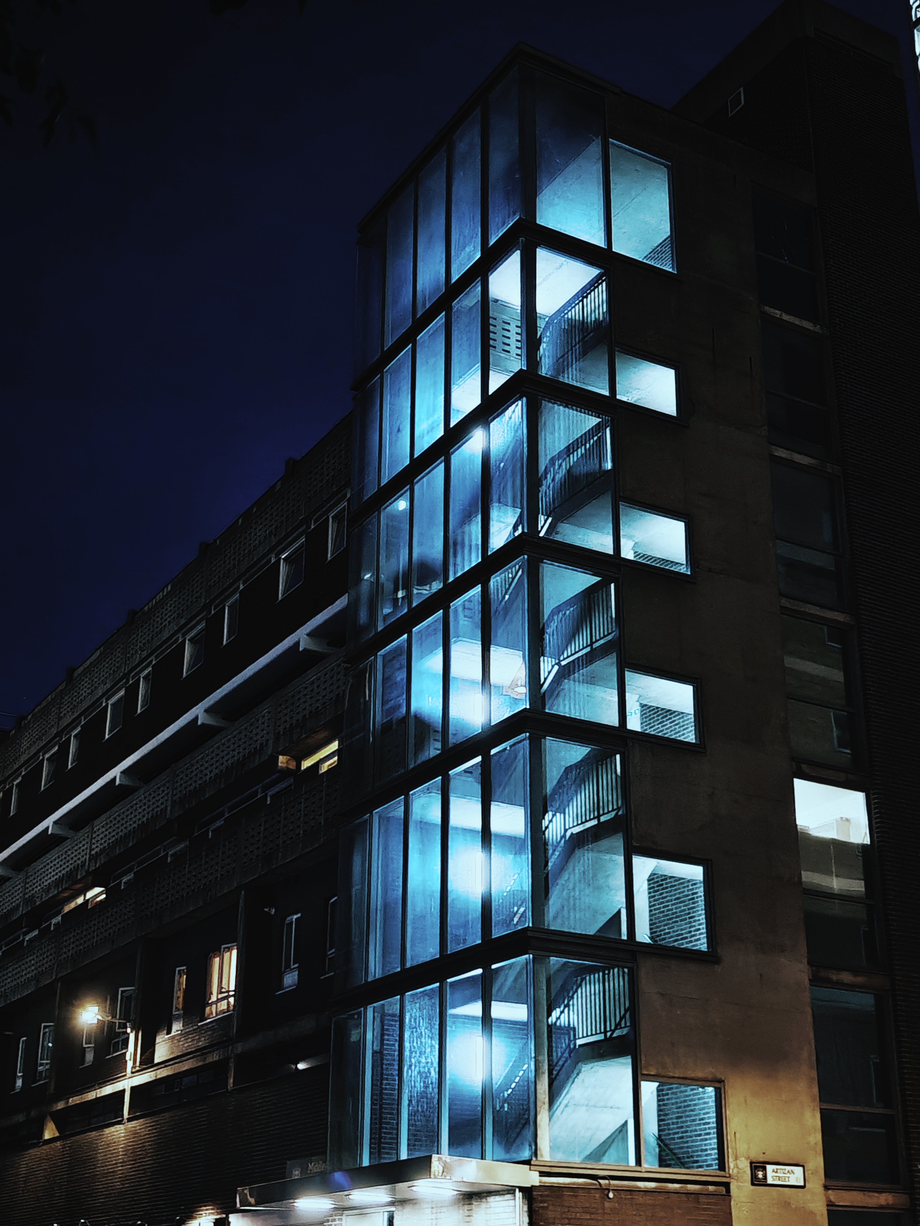 Stairwell in a tall building lit up blue at night
