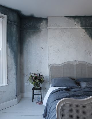 blue bedroom with distressed paint effect and rattan headboard