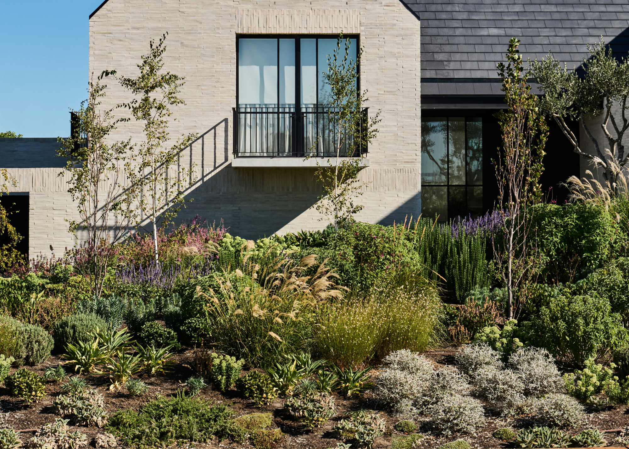 A lush garden with ground covering, shrubs, flowers, and tress