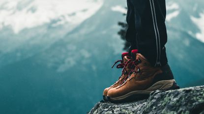 best hiking boots 2022: person standing on a rocky mountain 