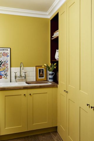 Yellow painted shaker style utility room with wooden worktop