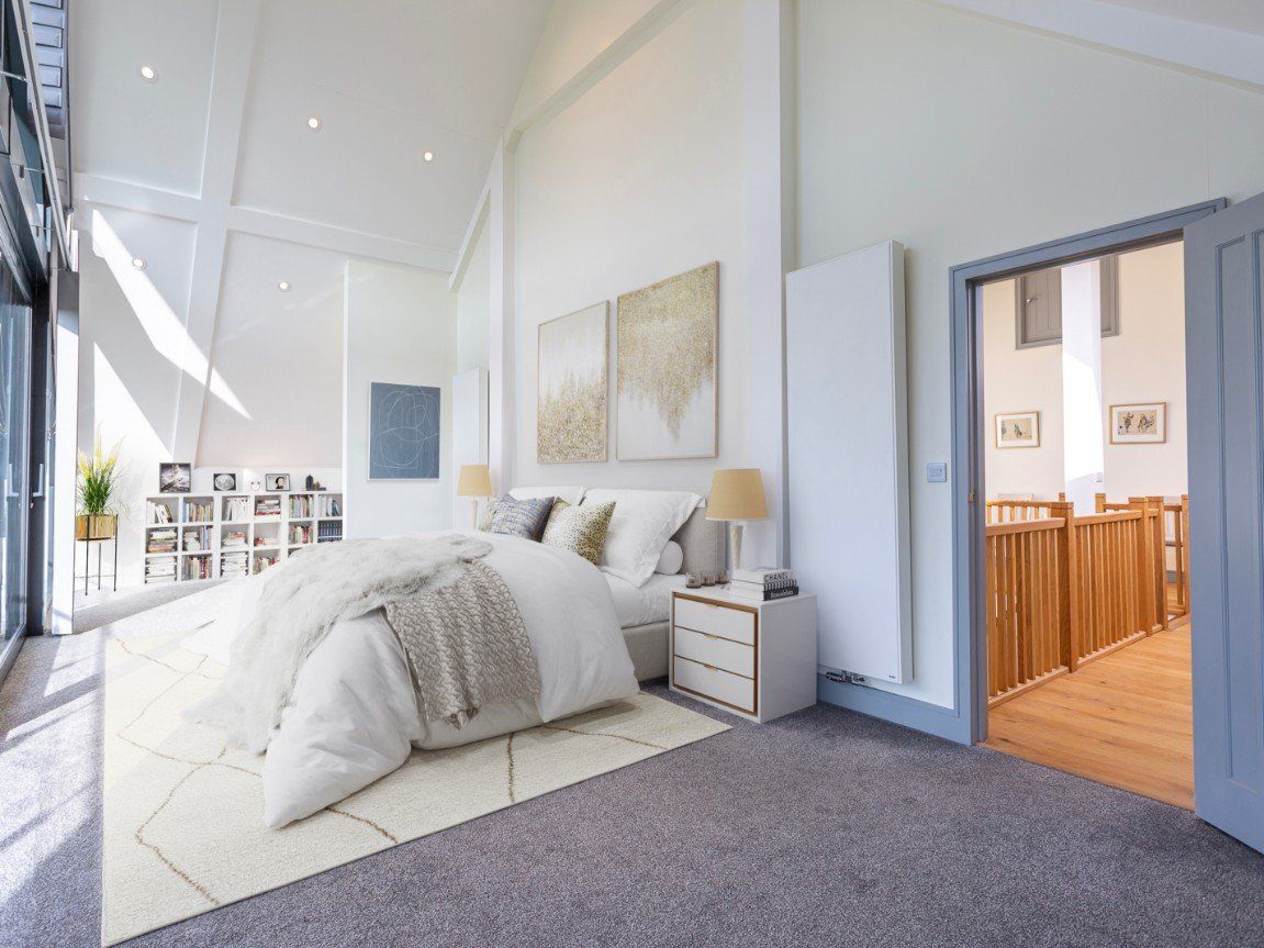 A bedroom with neutral grey decor and large doors
