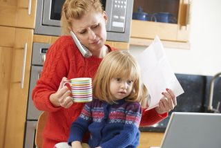 A mom holds her daughter, looking stressed