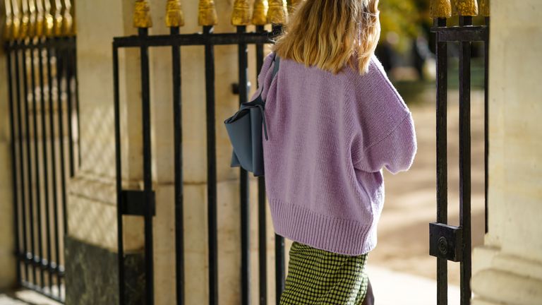 paris, france october 26 a passerby wears a pale purple mauve wool oversized pullover, a yellow and black skirt with printed patterns, a blue bag, on october 26, 2020 in paris, france photo by edward berthelotgetty images