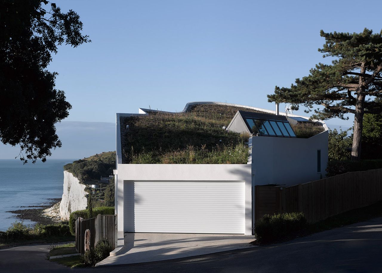 white house with green roof and view of garage