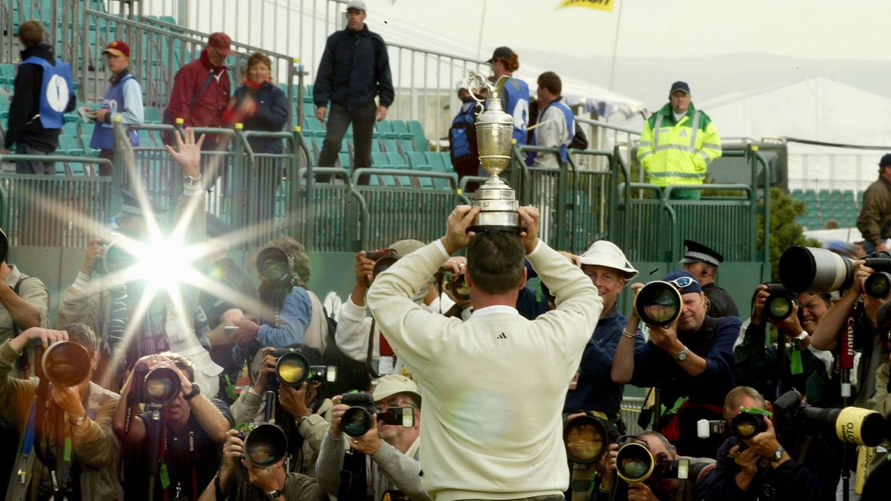 Todd Hamilton faces the photographers while holding the Claret Jug above his head