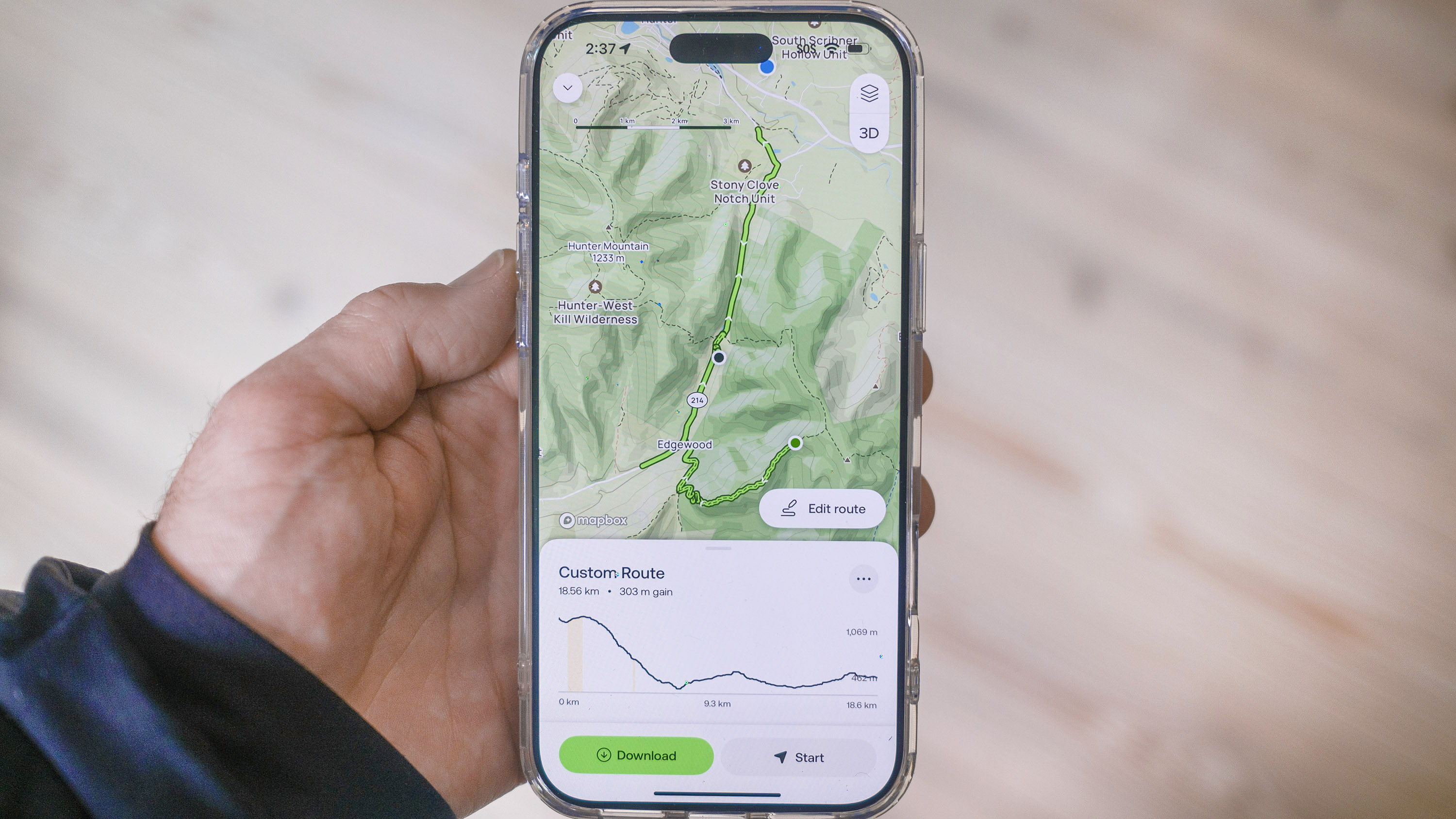 Close-up of an AllTrails user's phone showing the new custom trail building feature