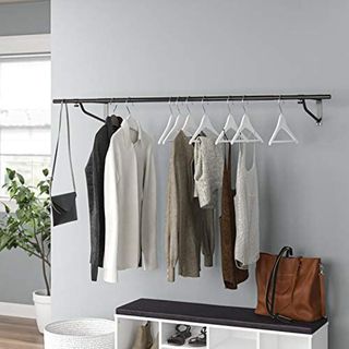 Black clothes rail on wall with clothes