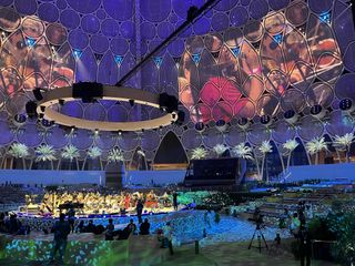 The Al Wasl Dome stage lit in vibrant colors as DPA microphones provide an immersive sound.