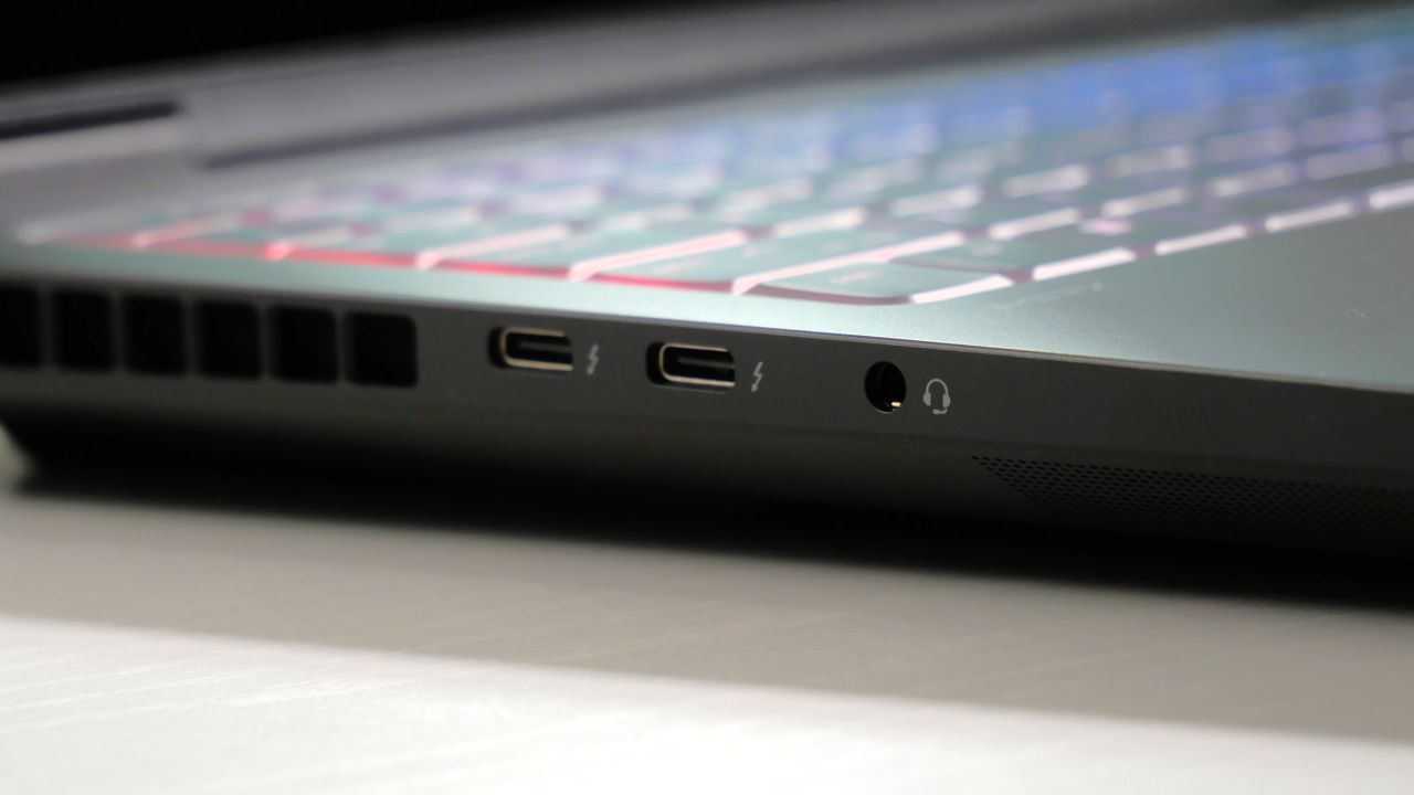 HP Omen Max 16 open on a white desk, highlighting its ports on the left side, including two Thunderbolt 4 and headphone jack.