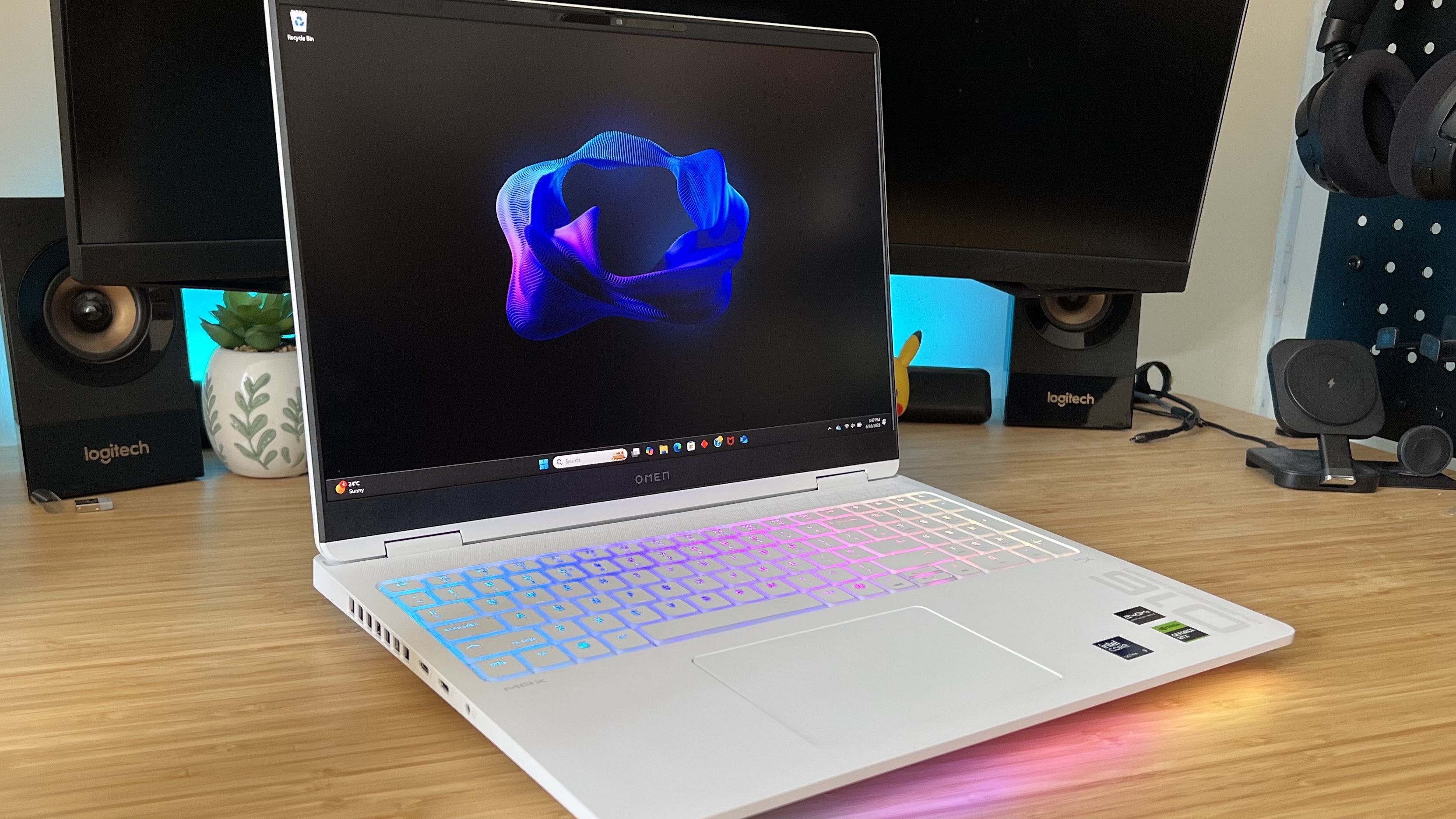 HP Omen Max 16 gaming laptop on a wooden desk with RGB lighting on