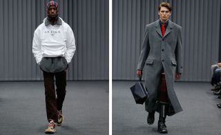 A separate front on view of two models on the catwalk, left in a white hoodie and a different hood up, the right in a large grey coat with a red tie holding a bag