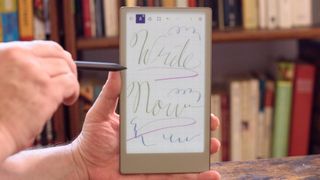 reMarkable Paper Pro Move tablet in front of a library of books, showing various writing screens and comparing the size to a Moleskine notebook