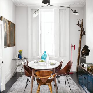 dining room with white wall and table with chairs