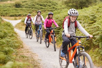 boy riding mountain bike with his sister and parents during a family camping trip